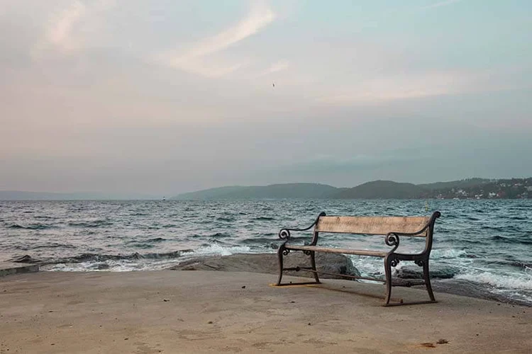 empty bench by the fjord at sunset